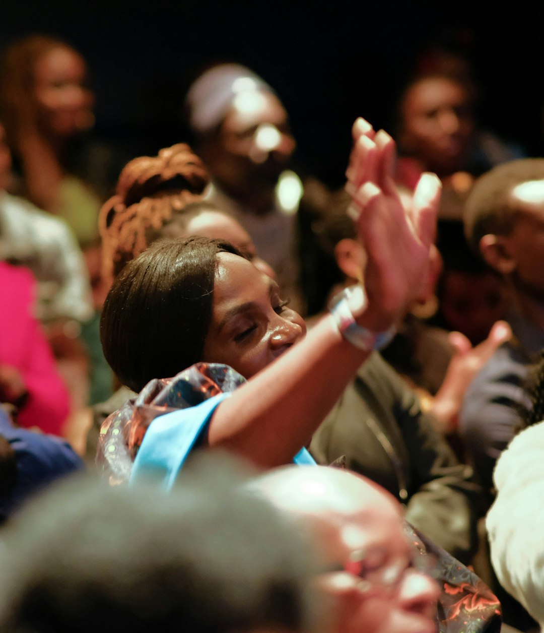 A picture of a woman raising her hand in church.